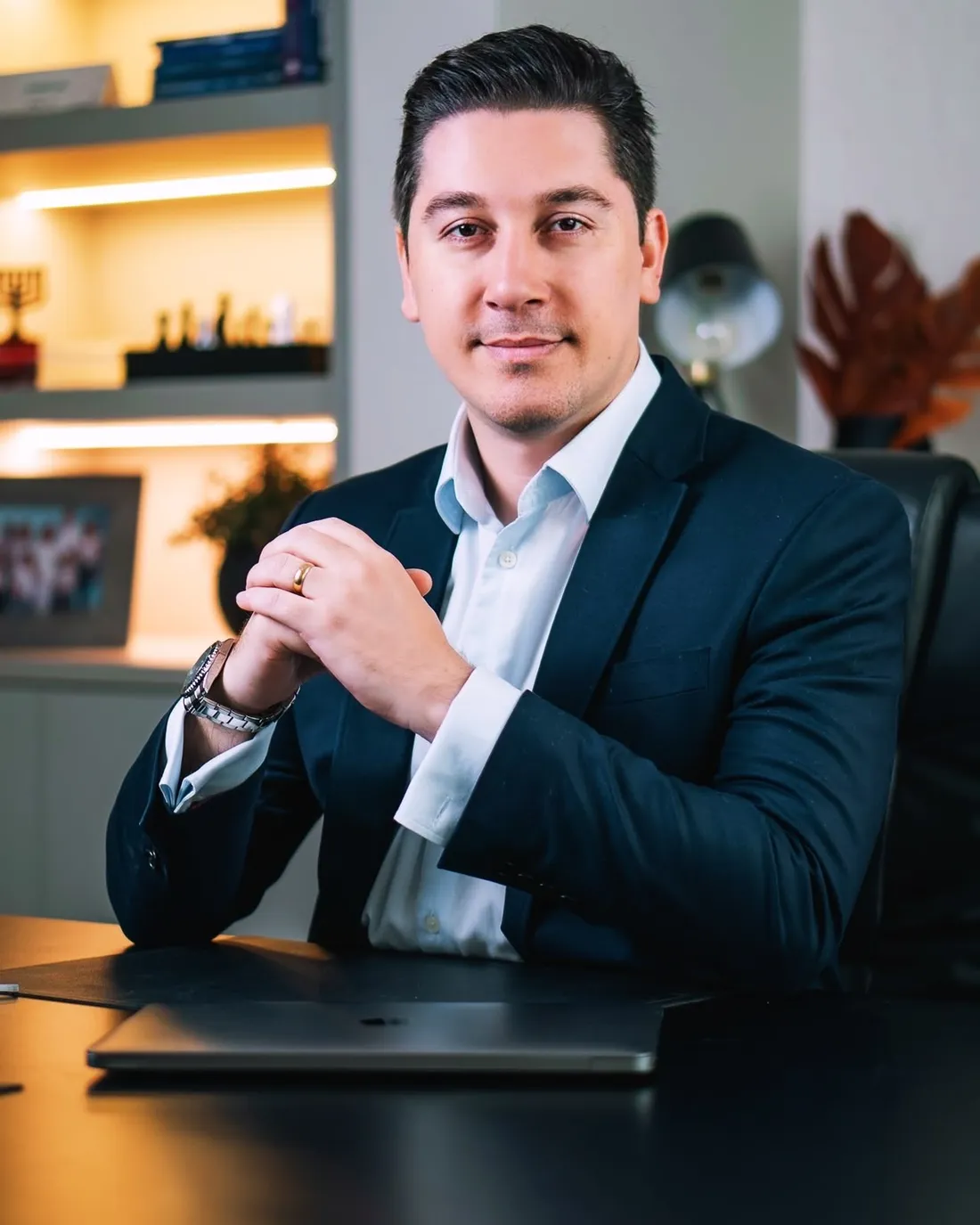 Luciano Leal, de terno azul-marinho, sentado à mesa